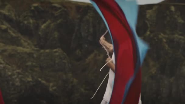 En fyr som svinger et stoff fra side til side i bakgrunnen av et Mossefjell – stockvideo