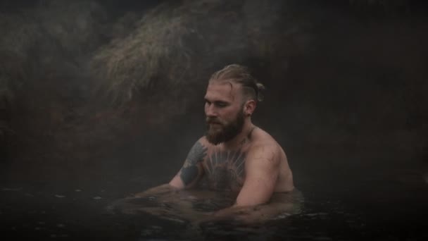 Мужская модель сидит на горячей ванне у весны — стоковое видео