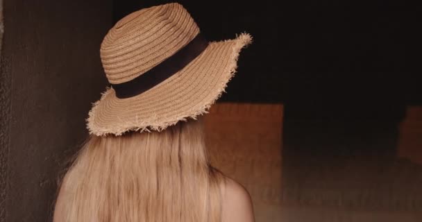 Dauerhafte Aufnahme einer Person mit langen blonden Haaren, die eine braune Mauer im Tempel beobachtet — Stockvideo