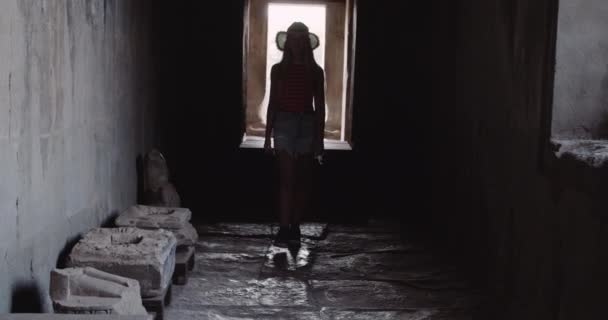 Ένα μακρινό σουτ μιας ξανθιάς νεαρής γυναίκας που περπατά μέσα σε αρχαία ερείπια — Αρχείο Βίντεο