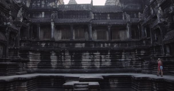 Um tiro largo constante de um modelo fêmea que anda fora de um templo arruina — Vídeo de Stock