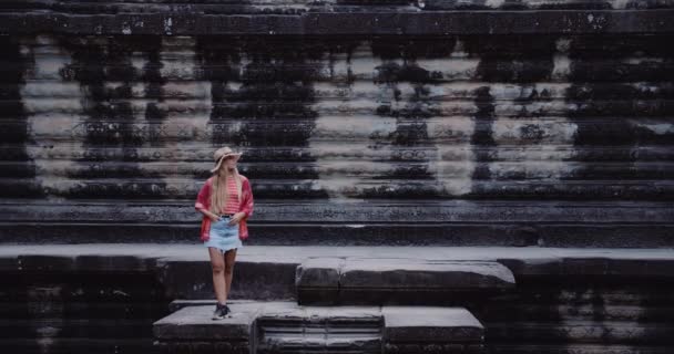 古代遺跡の壁にプラットフォーム上のカメラのブロンド女性モデル — ストック動画