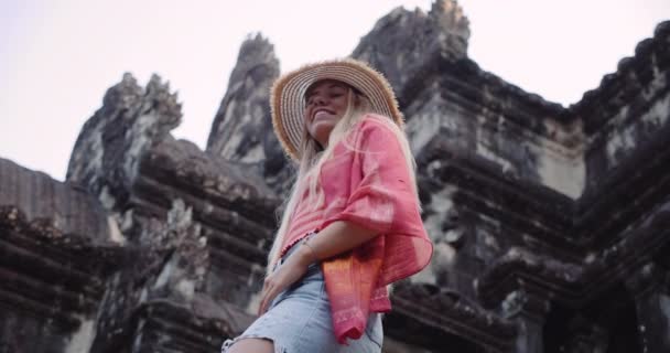 Una giovane bionda turista si posa con il cielo senza nuvole sullo sfondo — Video Stock