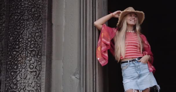 Una hermosa modelo femenina posa en una pared con un diseño intrincado — Vídeos de Stock