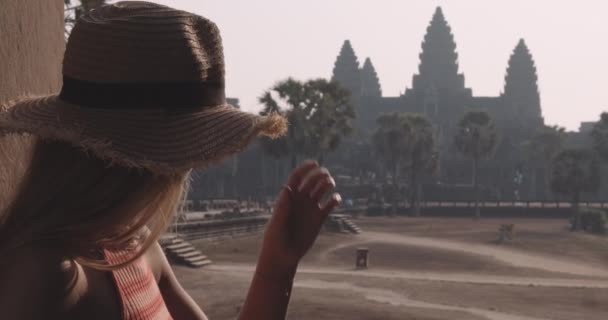 Young Traveler Views an Ancient Structure With the Camera at Her Back — Stock Video