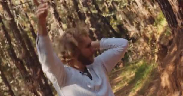 Man danst energiek in het bos — Stockvideo