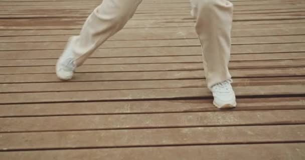 Mulher dançando em tênis no cais à beira-mar — Vídeo de Stock