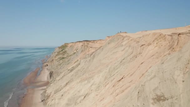 Drone aéreo tiro de formação bela duna cercado por tons de mar azul — Vídeo de Stock