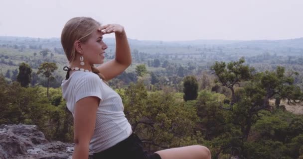 Kvinnliga vilar Bekväm på en sten med hisnande landskap i bakgrunden — Stockvideo
