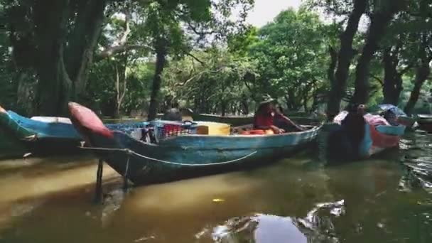 Kambodjanska lokalbefolkningen på deras parkerade båtar på ström av kaffe-färgade floden — Stockvideo