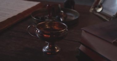Tahta bir yüzeye yerleştirilmiş saplı bir pirinç kadeh.