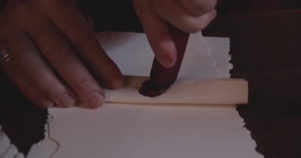 Finger versiegeln eine alte Schriftrolle mit rotem Wachs — Stockvideo