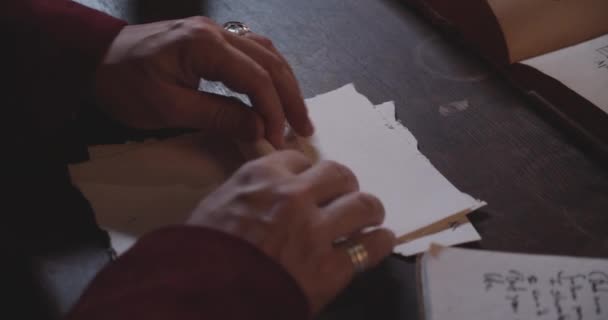 Τα χέρια ενός ατόμου κυλούν ένα γράμμα και το σφραγίζουν με ένα κόκκινο κερί — Αρχείο Βίντεο