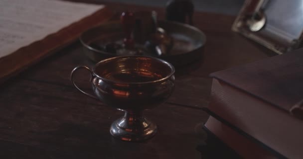 A Brass Chalice With a Handle Placed on Top Of a Wooden Surface — Stok Video