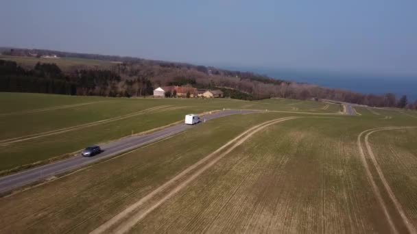 Luchtfoto van een wit voertuig na een pad met uitzicht op de majestueuze hemel — Stockvideo