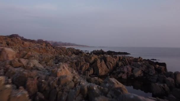 잔잔 한 대양의 웅장 한 선창에서 분산된 바위 층의 플라잉 샷 — 비디오
