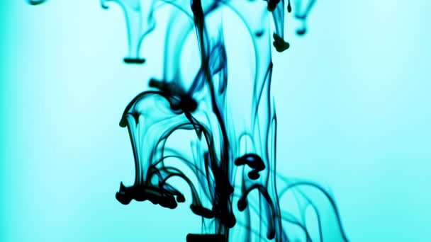 Abstrakt video av blå bläck frigörs ovan i vatten på ljusblå bakgrund — Stockvideo