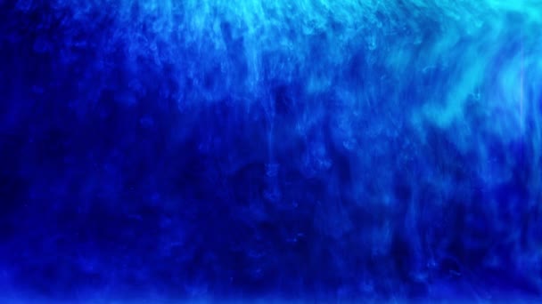 Tiro abstracto de tinta blanca salpicado lentamente sobre un fondo azul — Vídeo de stock