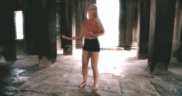 Μια χορεύτρια χορεύει παθιασμένα μέσα σε ένα ναό της Καμπότζης — Αρχείο Βίντεο