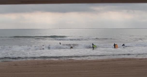 Steady Wide Shot van Surfers Riding the Waves in het Zandstrand — Stockvideo