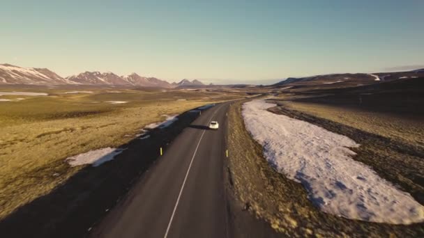 Vue Aérienne D'une Voiture Blanche Voyageant Sur La Route Et Un aperçu Des Montagnes Couvert De Neige — Video