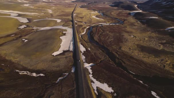 Воздушный шар узкой дороги посреди величественного поля с растаявшим снегом — стоковое видео