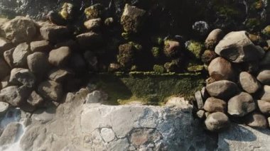 Kuş bakışı görüntü Kayalık bir nehirden akan su yosunla kaplı.