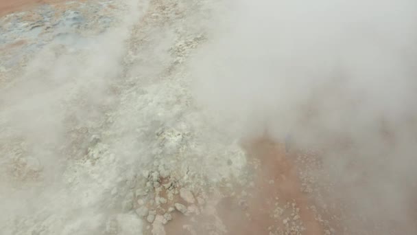 Drone sobre el hombre caminando en el paisaje volcánico brumoso — Vídeos de Stock