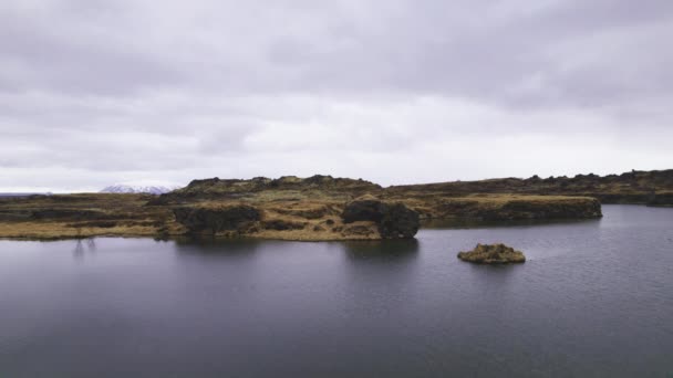 Пейзаж в Исландии, окруженный спокойными водами озера и чистым небом — стоковое видео