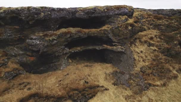 Revelação aérea tiro de uma estrutura de pedra coberta de grama murcha — Vídeo de Stock
