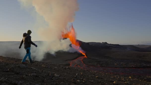 男子观看熔岩从喷发的Fagradalsfjall火山流出来 — 图库视频影像
