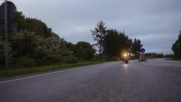 Lange weg met een persoon rijden op een motorfiets op een grijze betonnen weg — Stockvideo