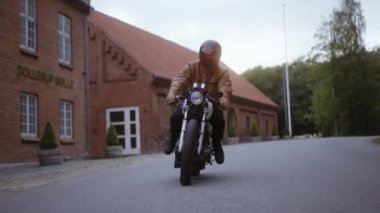 Açık Gökler Altında Kahverengi Tuğla Bina Arkaplanlı Motosiklet