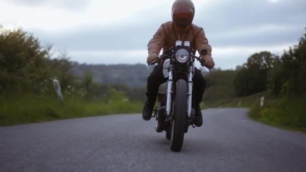 Tracking Shot of Motorcycle Soepel gereden op de weg omgeven door bomen — Stockvideo
