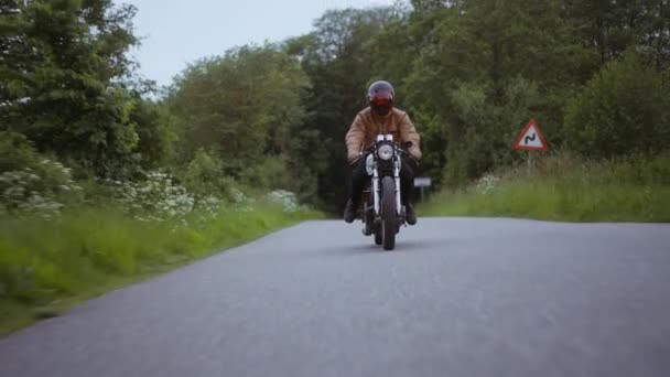 Motorcycle Smoothly Driven on a Narrow Road Surrounded by Lush Green Trees — Stockvideo