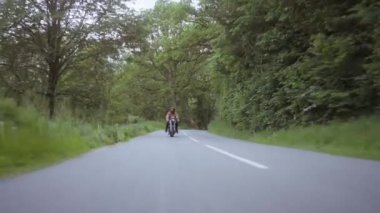 Motorsiklet Zengin Ormanın Arkaplanıyla Beton Bir Yolda Sürülüyor