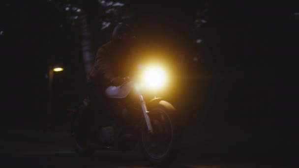 Moto avec phares allumés dans le fond sombre, prise de vue large — Video