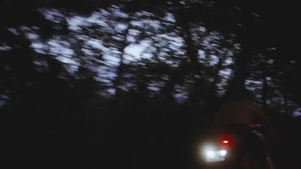 A Wide Tracking Shot of a Motorcycle Driving on a Dark Road — Stockvideo