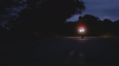 Karanlık Gökler Altında Karanlık Bir Yol 'da Işıklı Motosiklet