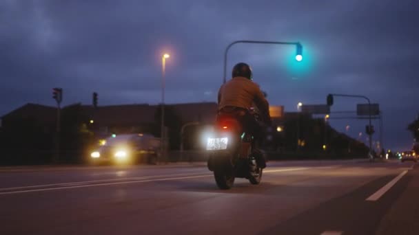 A Person Riding on a Motorcycle on a Road in the Backdrop of Buildings — ストック動画