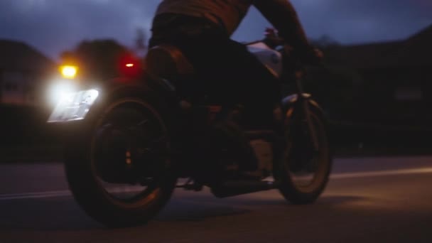 Una moto guidata su una strada liscia con lo sfondo di edifici — Video Stock