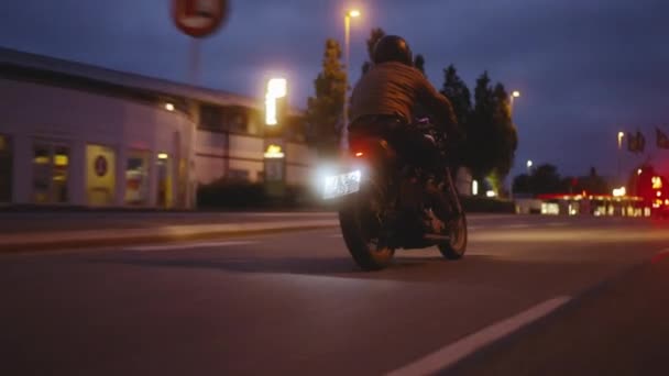 A Wide Tracking Shot of a Motorcycle Driving on a Streetlight Lit Road — Αρχείο Βίντεο