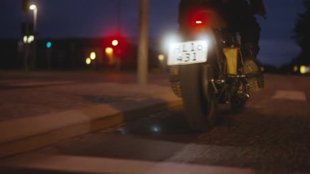 Motocicleta en una carretera en el telón de fondo de un edificio, farolas — Vídeos de Stock