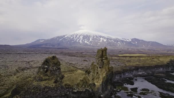 Montagne avec des plaques de neige, structure en pierre près des eaux calmes de la mer — Video