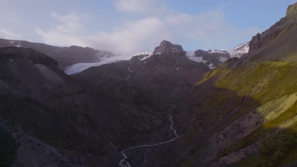 Vista aérea impresionante de las montañas con parches de nieve en el pico contra el cielo — Vídeos de Stock