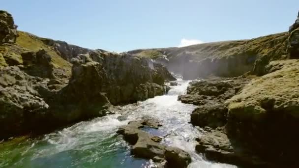Revealing Drone Shot From Rocky Waterfalls to Vast Field and Snowy Mountaintop — Vídeos de Stock