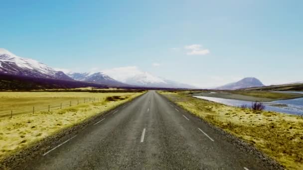 Niekończący się Horizon drogi otoczony pasmami górskimi pod błękitnym niebem — Wideo stockowe