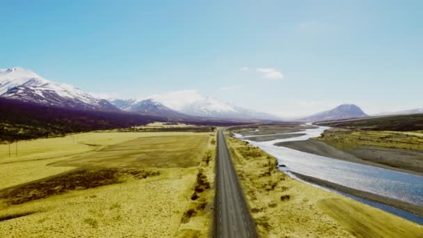 Narrow Road, Open Field, Calm River and Snowy Mountain Ranges — Stockvideo