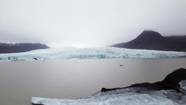 Icebergs Floating in Water and View of the Mountain Ranges With Patches of Snow — Stockvideo