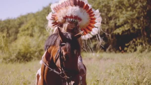 Meisje in indiaanse hoofdtooi te paard — Stockvideo